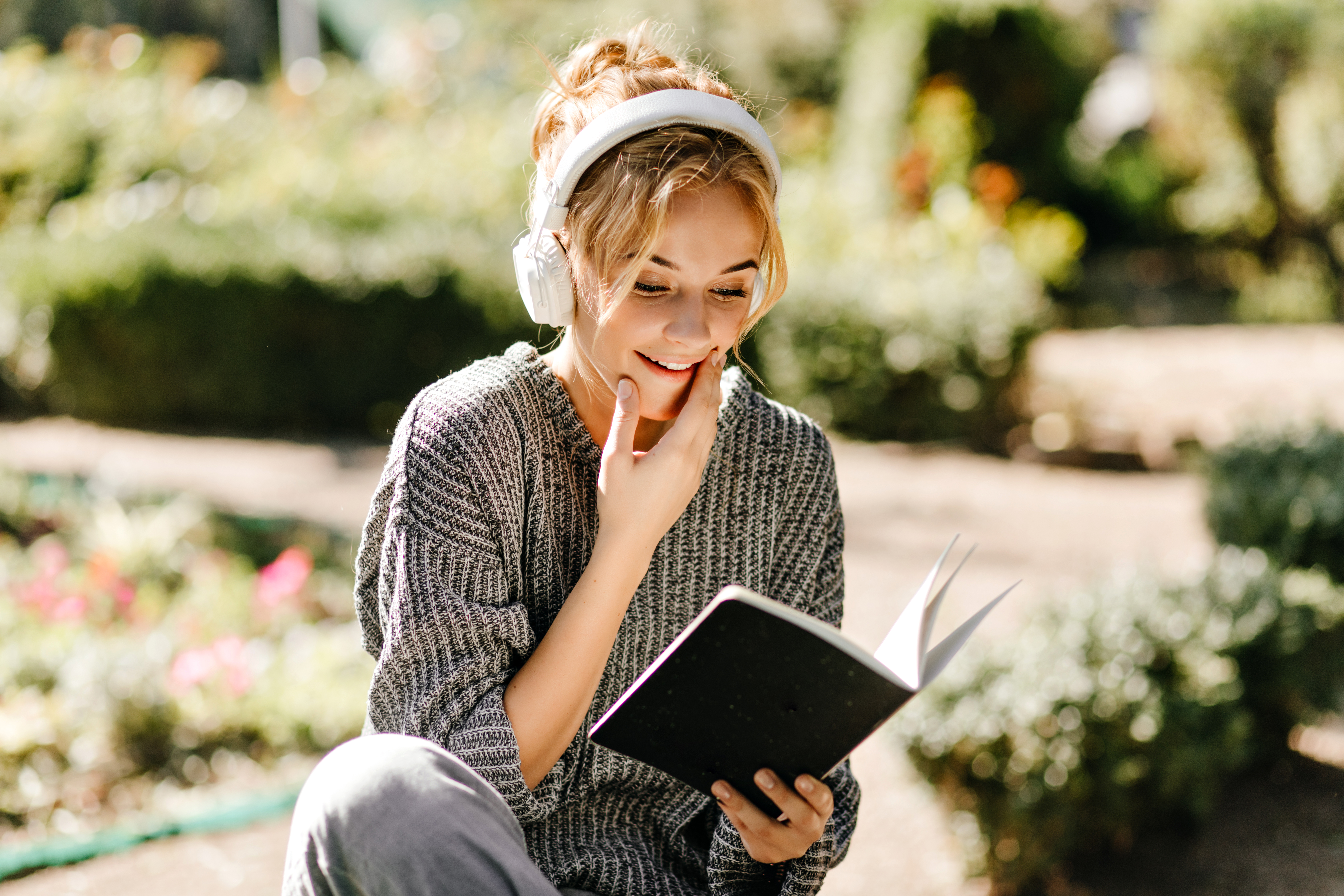 Une femme qui lit un livre en écoutant un podcast